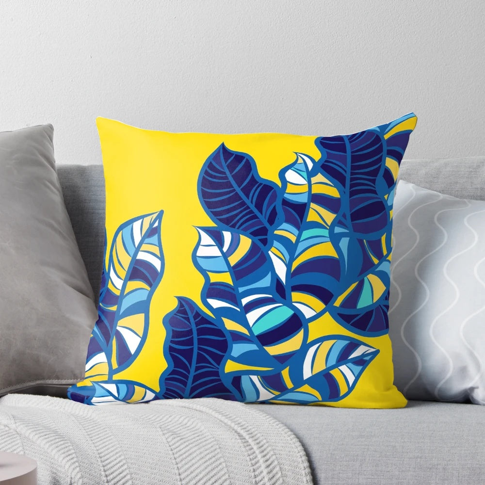 Colorful tropical leaf pattern printed on a yellow throw pillow