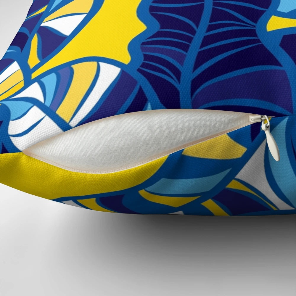 Colorful tropical leaf pattern printed on a yellow throw pillow