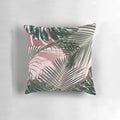 Close-up of a pink and green tropical leaves design on a pillow.