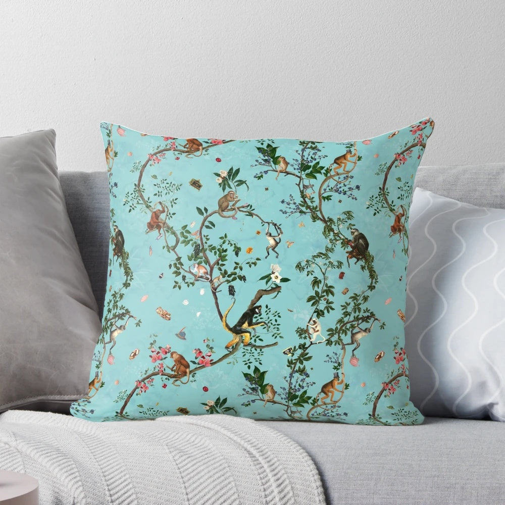 Colorful watercolor-style monkey and floral design on an aqua blue decorative pillow