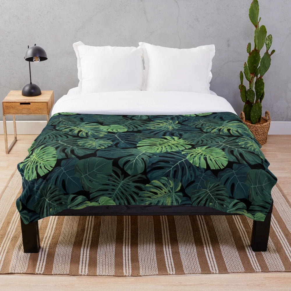 Lush green monstera leaves printed on a cozy plush blanket for home decor