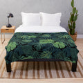 Lush green monstera leaves printed on a cozy plush blanket for home decor