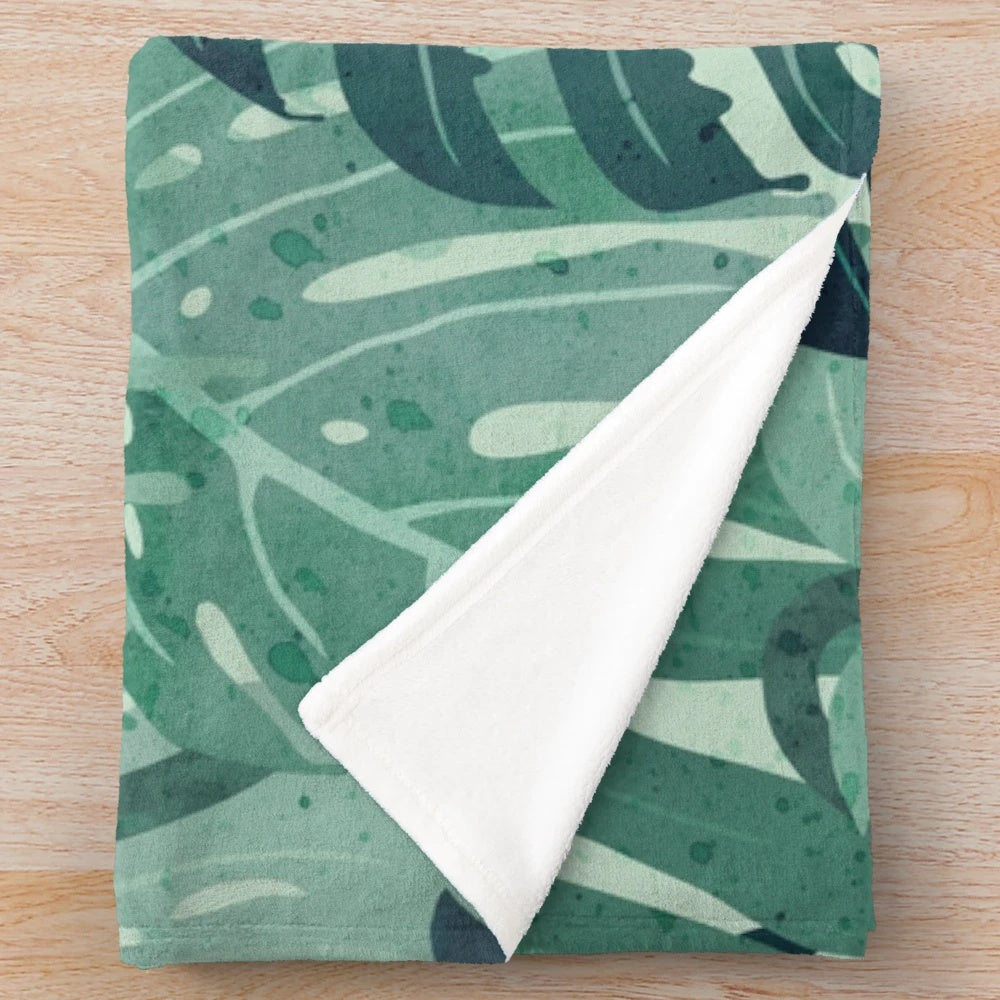 Plush monstera leaf blanket in a surreal, tropical design