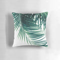 Decorative pillow featuring a digital art design of tropical palm leaves in shades of green on a white background.
