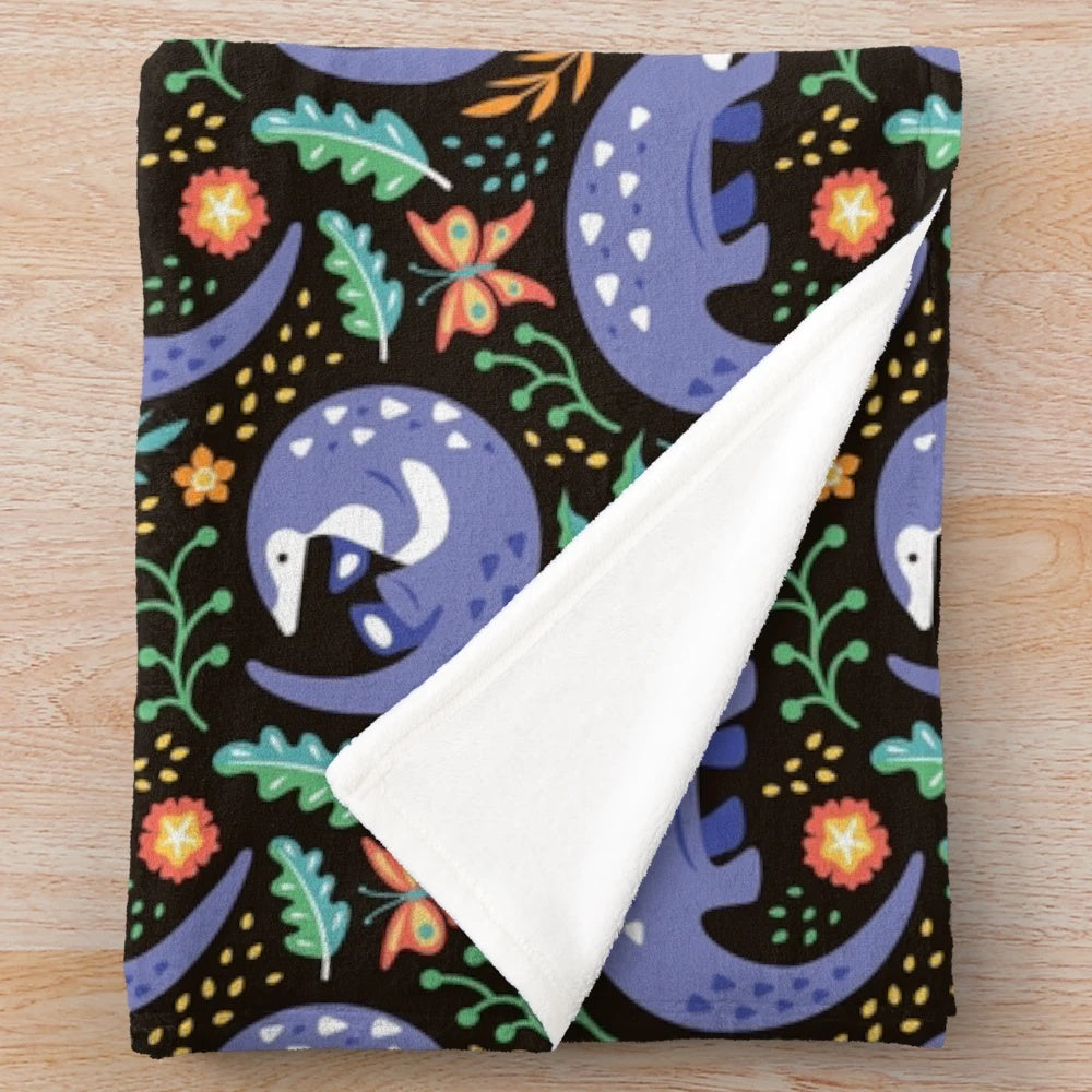 Pangolin pattern plush blanket with tropical leaves, plants, and butterflies