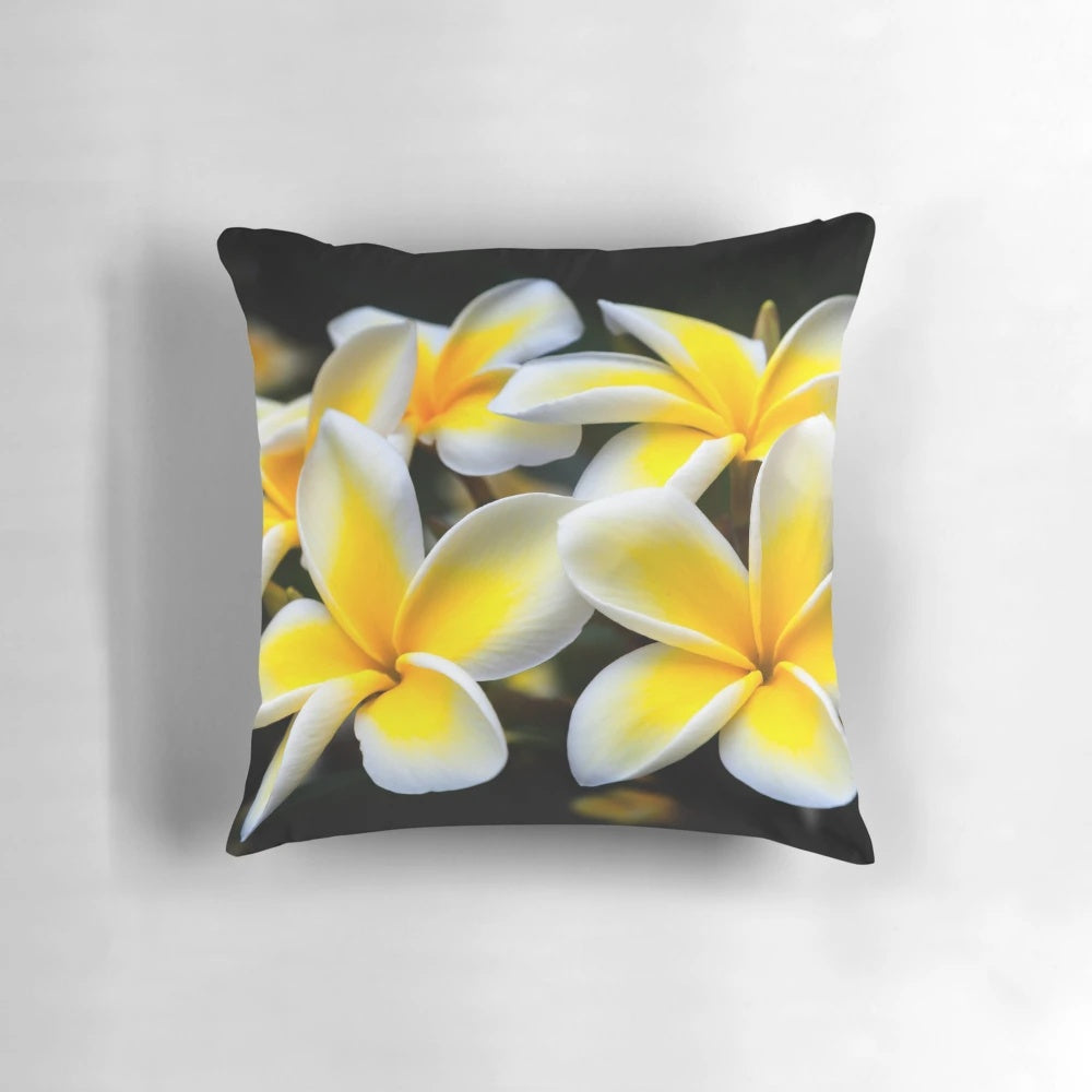 Vibrant yellow plumeria or frangipani flowers on a tropical floral pillow
