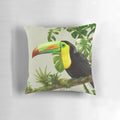A decorative throw pillow featuring a vibrant illustration of a toco toucan perched on a bromeliad plant against a lush, green background.
