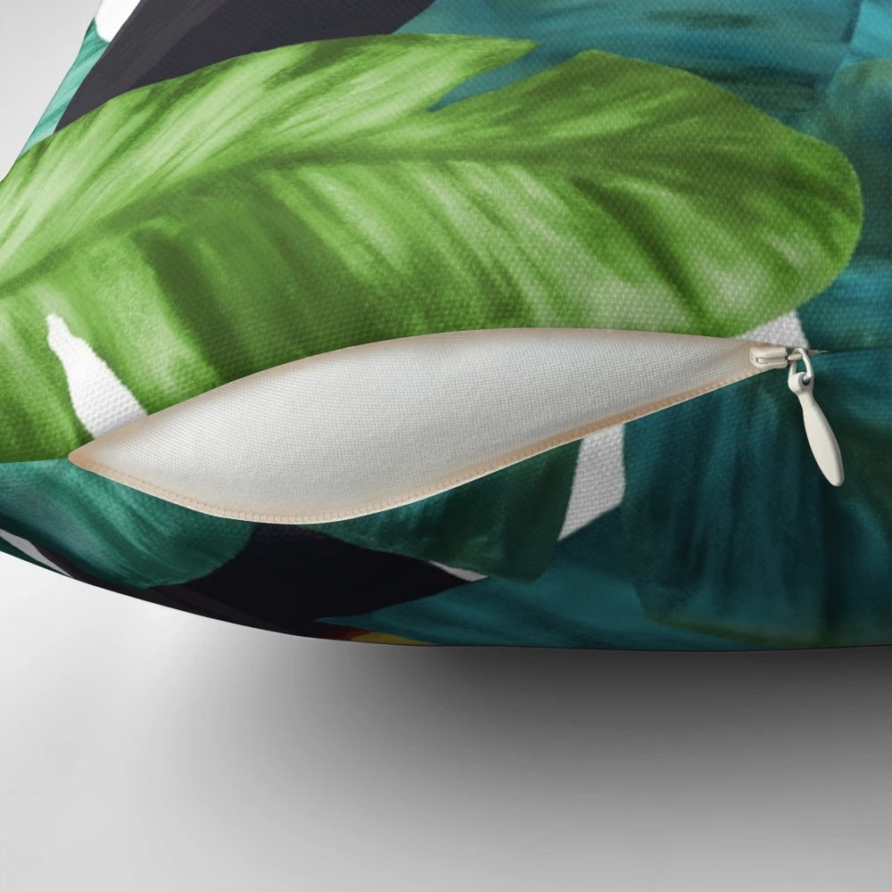 Tropical pillow with a colorful pattern featuring toucans and banana leaves