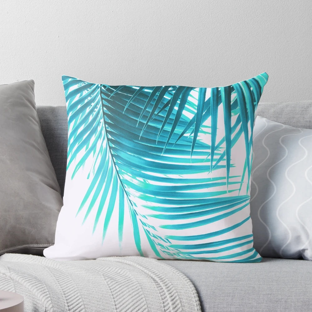 A decorative pillow featuring a digital artwork of tropical palm leaves in shades of turquoise, perfect for adding a summer vibe to any coastal or beach-inspired space.