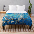 Turquoise plush blanket featuring a vincent van gogh inspired almond blossom floral design