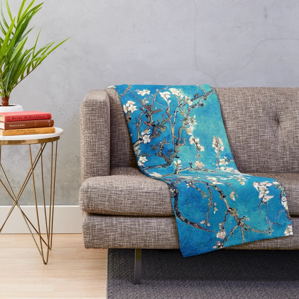 Turquoise plush blanket featuring a vincent van gogh inspired almond blossom floral design