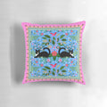 Tuxedo cat resting on a pillow with a hummingbird design