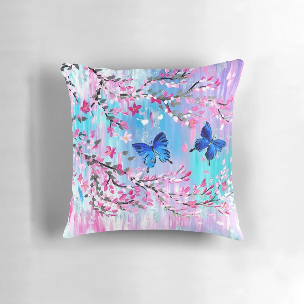 Vibrant blue Ulysses butterflies fluttering amidst delicate Japanese cherry blossoms on a soft pillow cover.