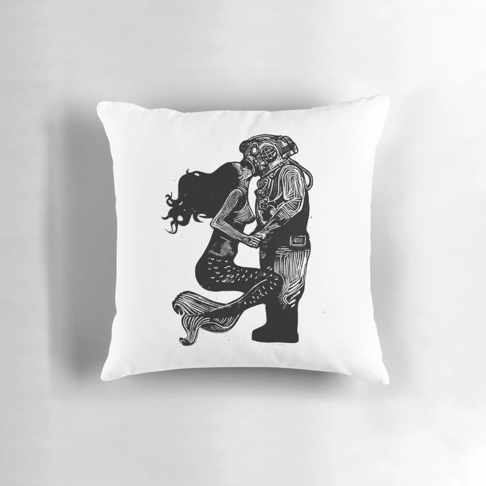 Handmade linocut print of a mermaid and diver kissing underwater on a decorative pillow