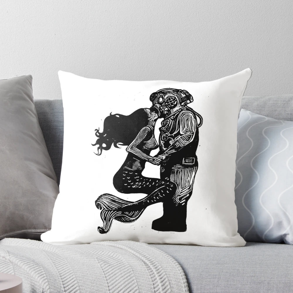 Handmade linocut print of a mermaid and diver kissing underwater on a decorative pillow