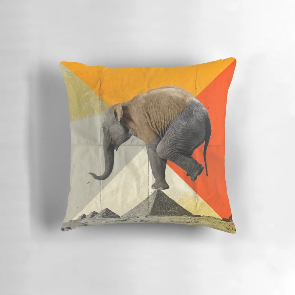 Decorative pillow featuring a graphic design of pyramids and an elephant in balance.