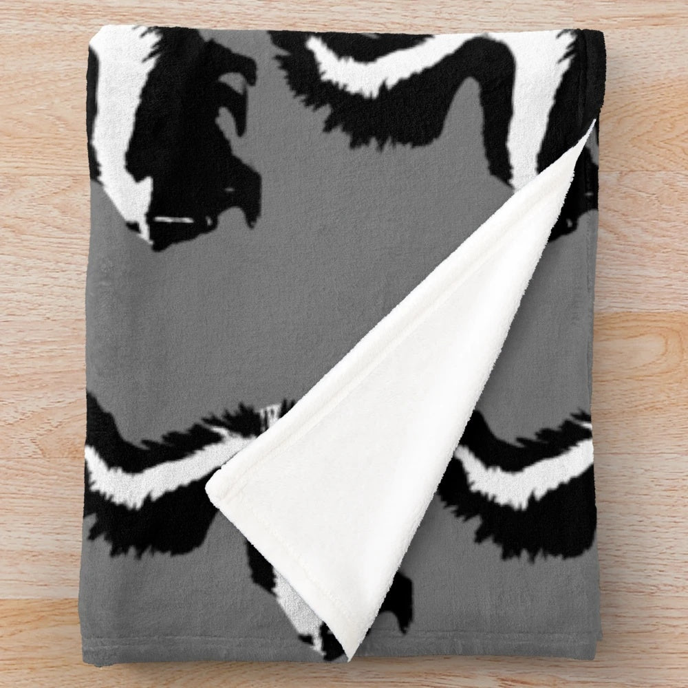 Skunk plush blanket with black and white animal print design