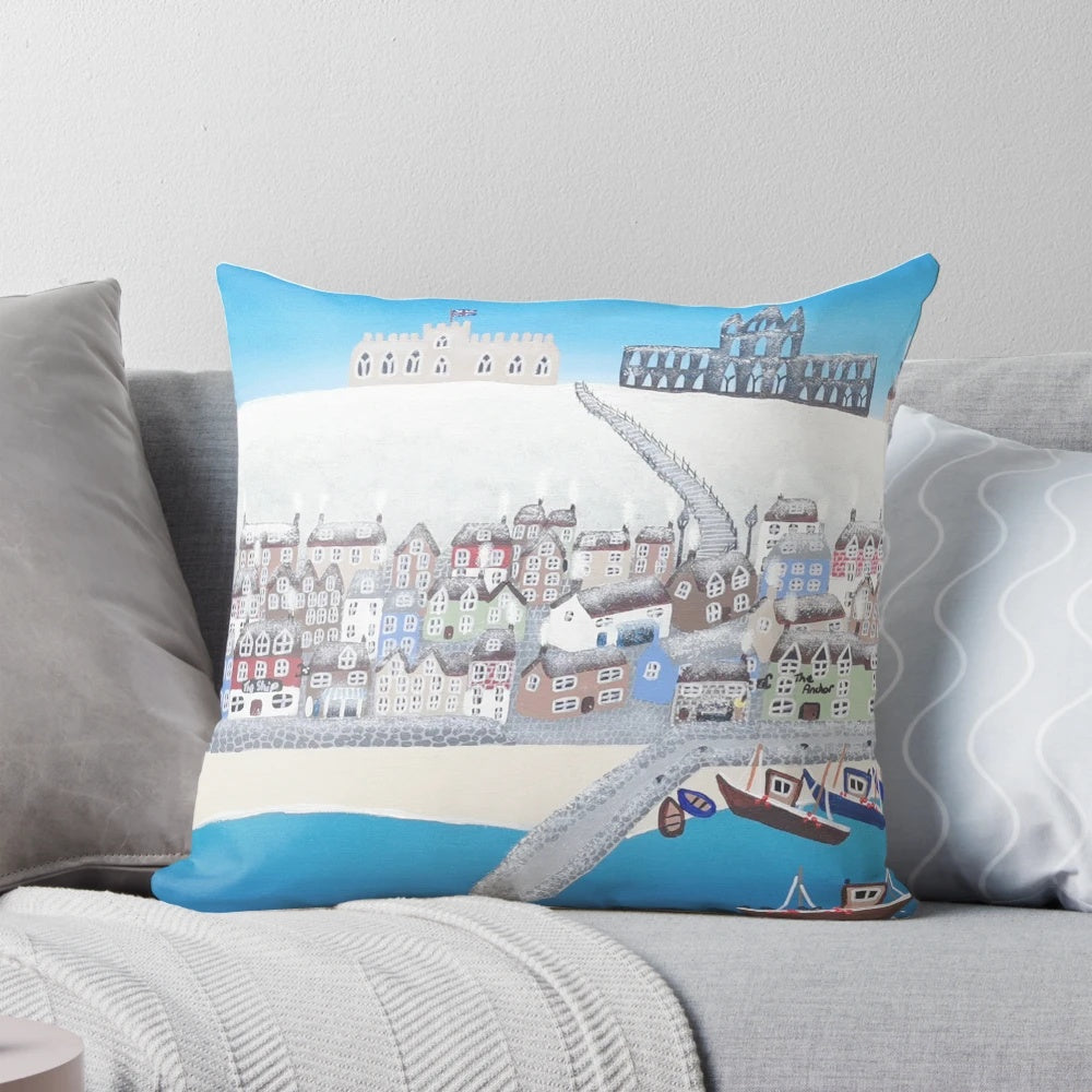 A contemporary art-inspired pillow featuring a wintery scene of Whitby, Yorkshire with the iconic abbey, boats, and snow-covered beach.