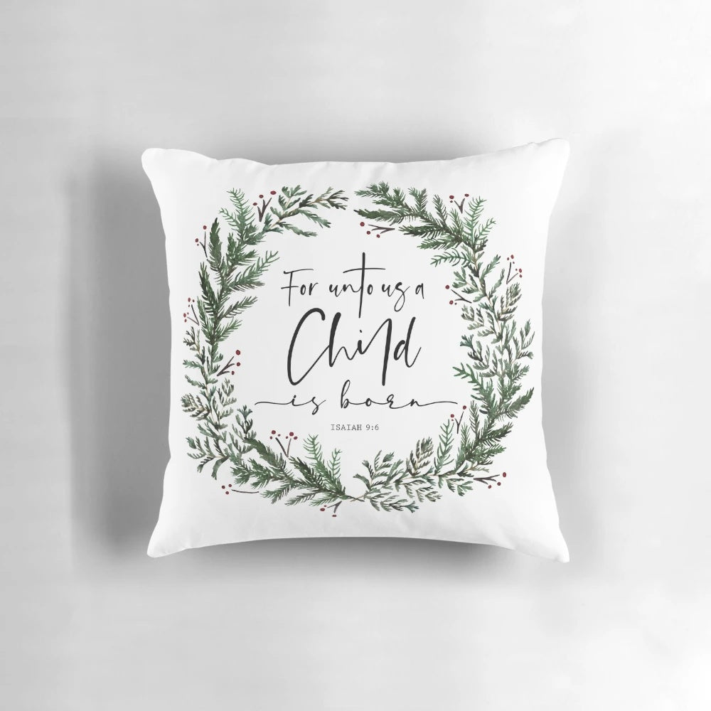 Pine wreath pillow with "Unto Us a Child is Born" bible verse text