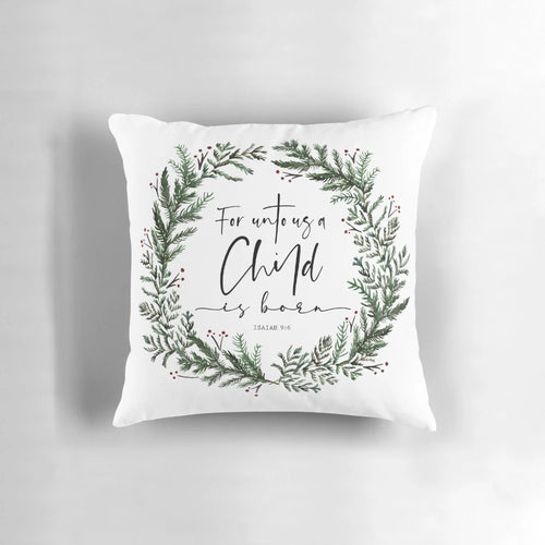 Pine wreath pillow with "Unto Us a Child is Born" bible verse text