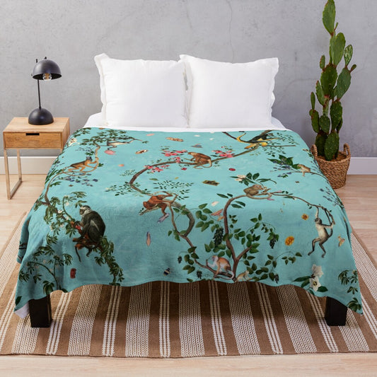 Soft and plush aqua-colored blanket with playful monkey and jungle plant designs