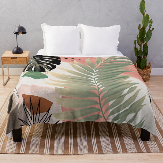 Plush blanket with tropical-inspired abstract art design featuring monstera leaves, palm fronds, and watercolor stripes