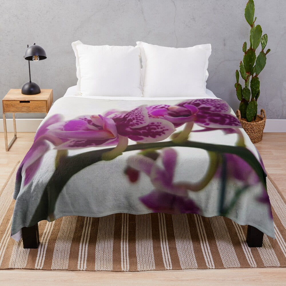 Soft and cozy plush blanket featuring a beautiful orchid design on a branch