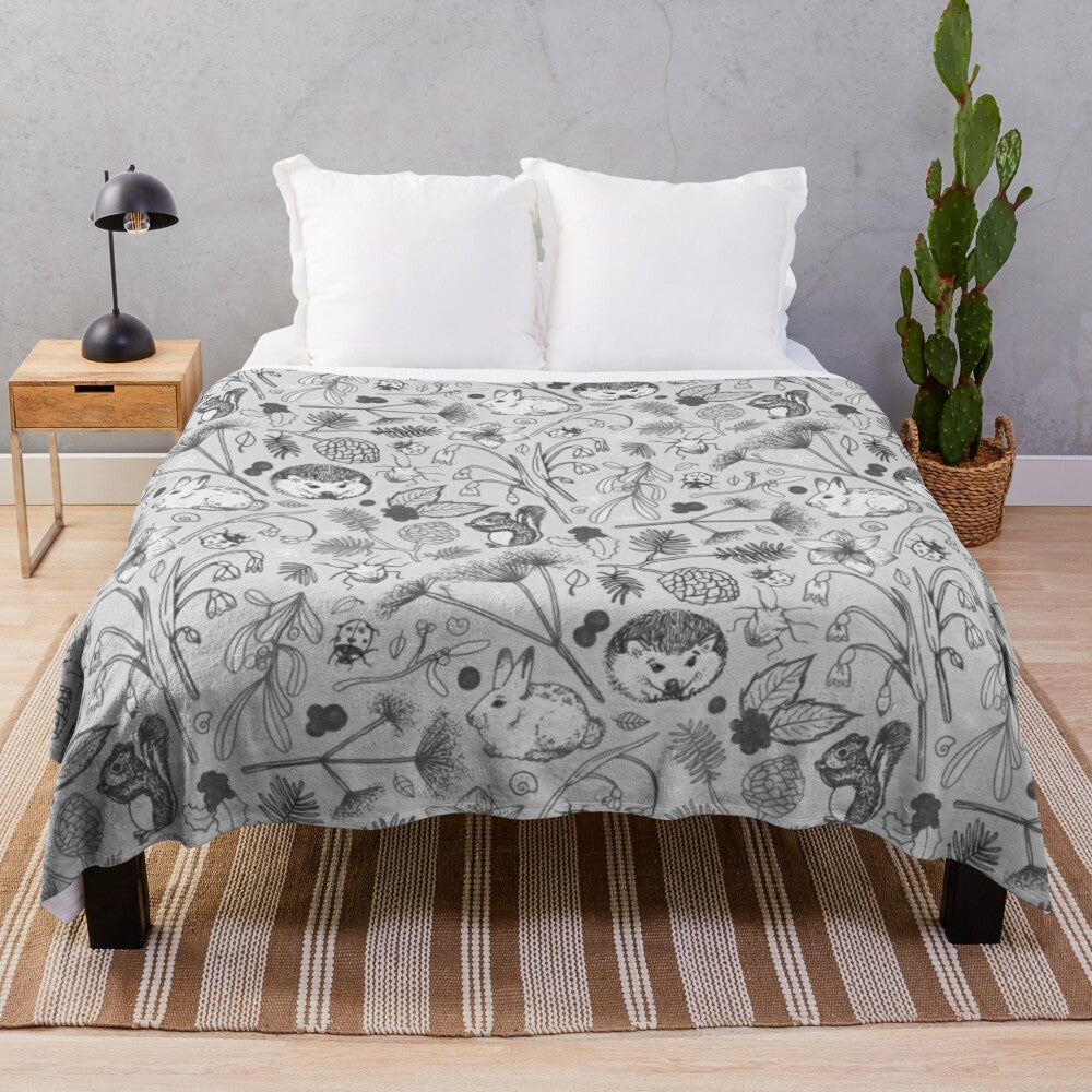 Cozy black and white plush blanket featuring whimsical woodland animals and nature motifs