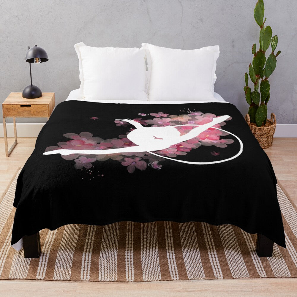 Plush blanket with pink silhouette of rhythmic gymnast leaping with hoop