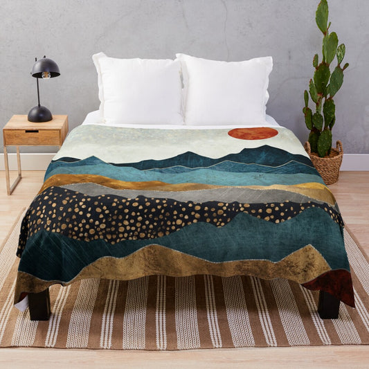 Soft and cozy amber plush blanket with a landscape design depicting a dusk sky over hills and mountains