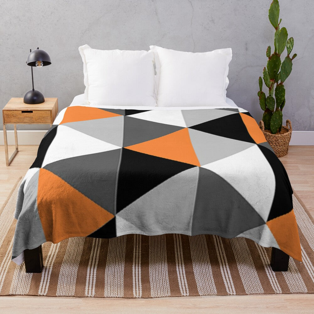 Geometric pattern plush blanket in orange, black, white, and grey colors