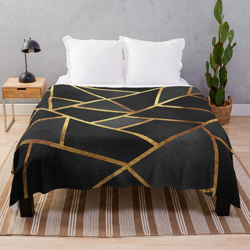 Black and gold geometric plush blanket with abstract marble pattern