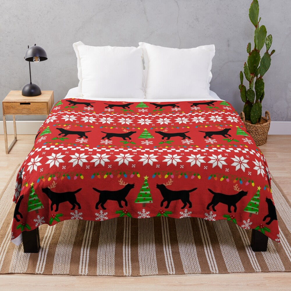 Black labrador retriever wearing reindeer antlers on a plush Christmas blanket