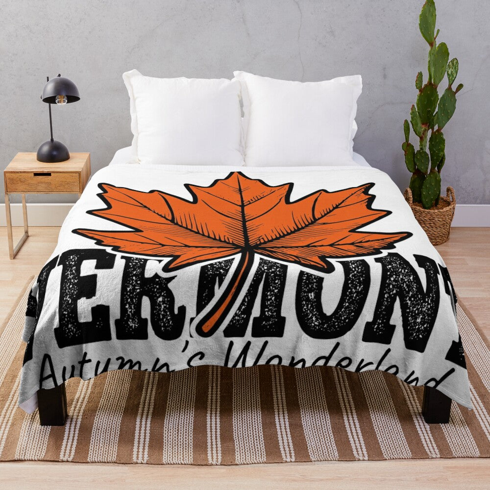 Plush blanket with illustration of vibrant orange maple leaves in an autumn landscape