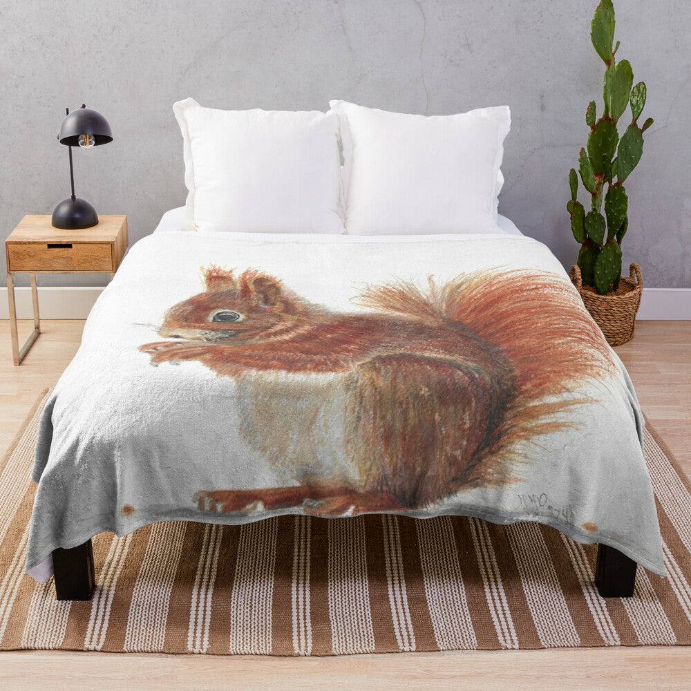 A cozy plush blanket featuring a red squirrel in a watercolor-style design, surrounded by autumn leaves and nuts.