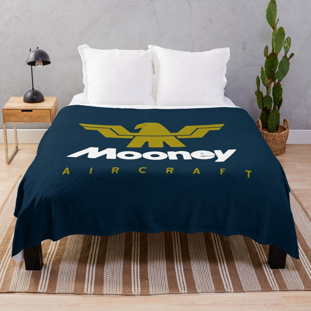 Soft and cozy plush blanket featuring a classic Mooney aircraft logo