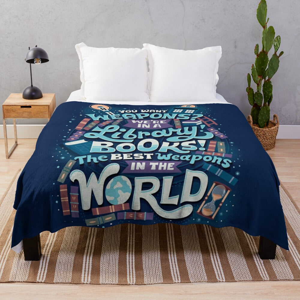 Plush blanket with the phrase "Books are the best weapons" in a stylized, hand-lettered design