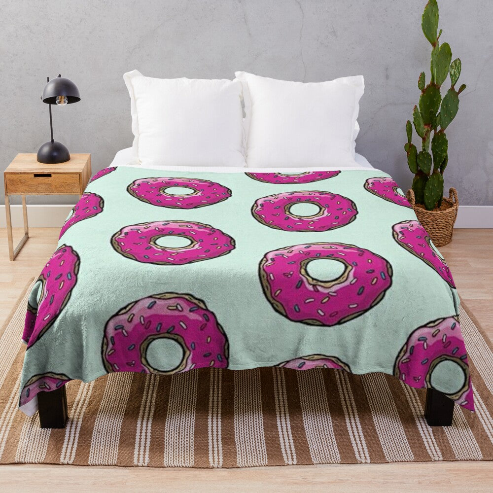 Plush blanket featuring a Simpsons-inspired donut pattern in pink and sprinkles