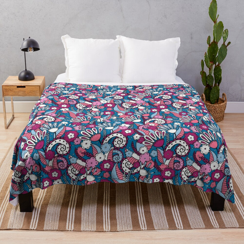 Plush blanket with floral doodle pattern on a dark blue background