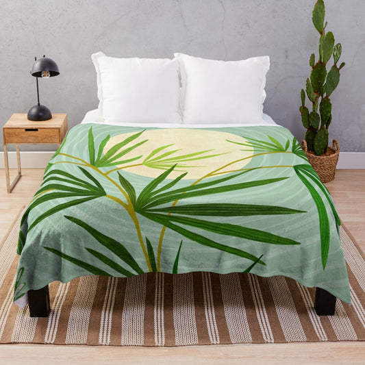 A plush blanket featuring a serene desert landscape with plants, cactus, and palm trees under a night sky.