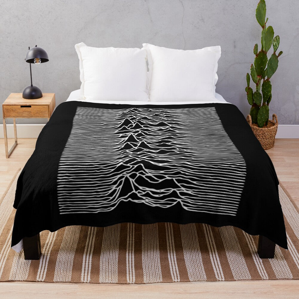 Monochrome plush blanket with 'Unknown Pleasures' album cover-inspired design