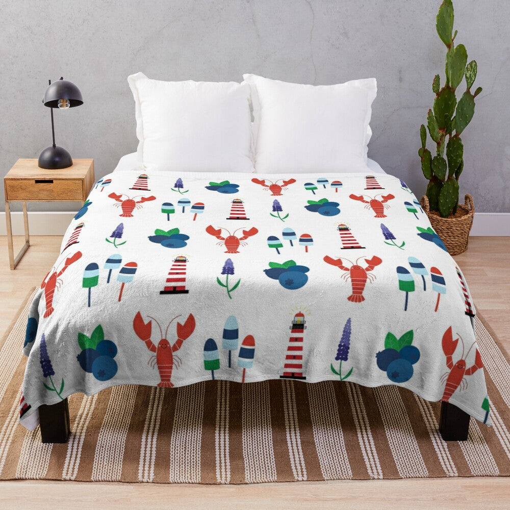 Plush blanket featuring Maine icons like lobster, blueberries, lighthouses, and lupins