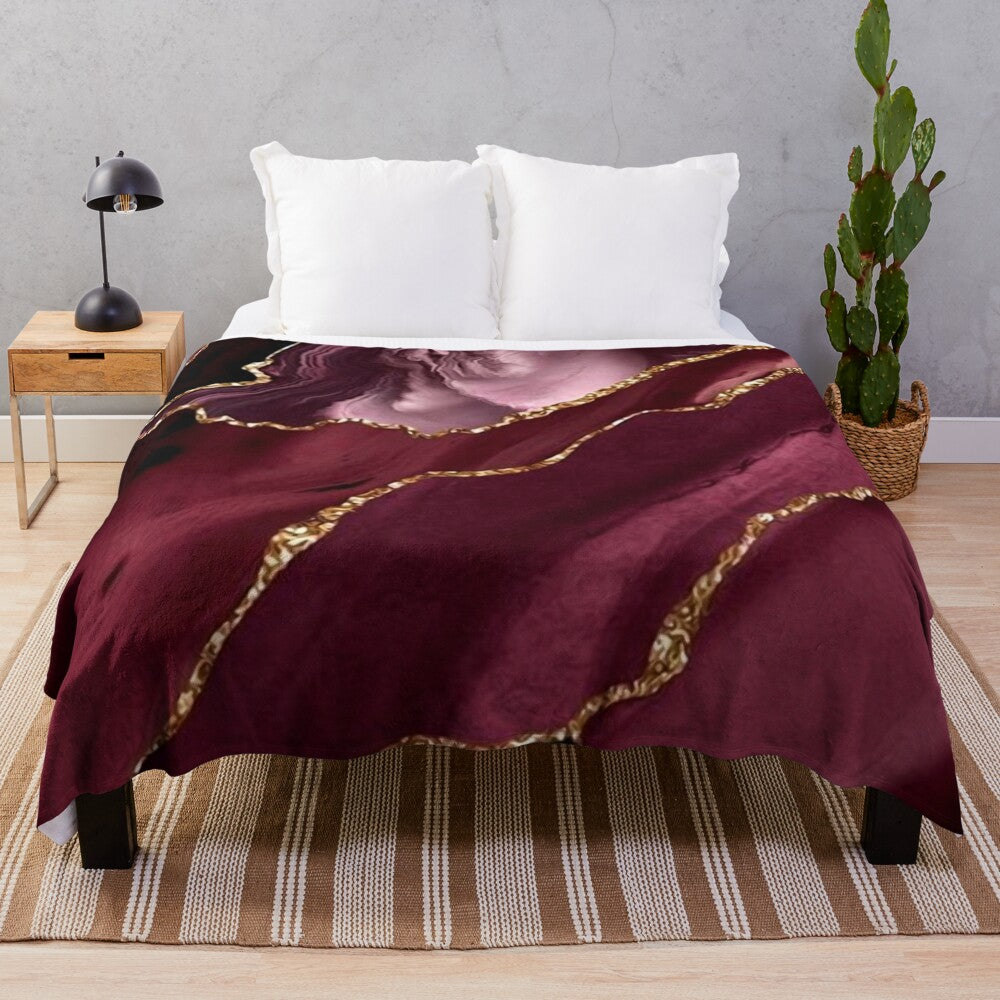 Burgundy and gold abstract patterned plush blanket