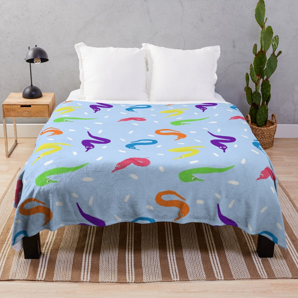 Colorful plush blanket featuring a whimsical worm on a string design