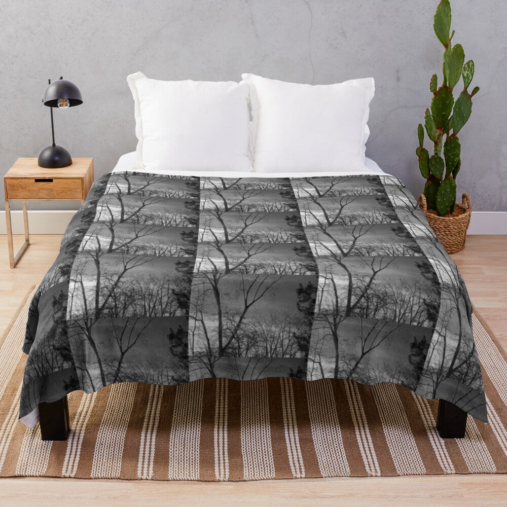 Plush blanket featuring a winter landscape with trees against a dark sky