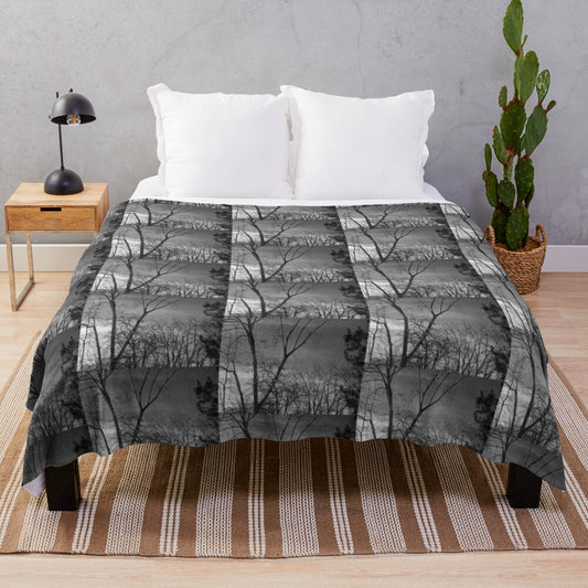 Plush blanket featuring a winter landscape with trees against a dark sky