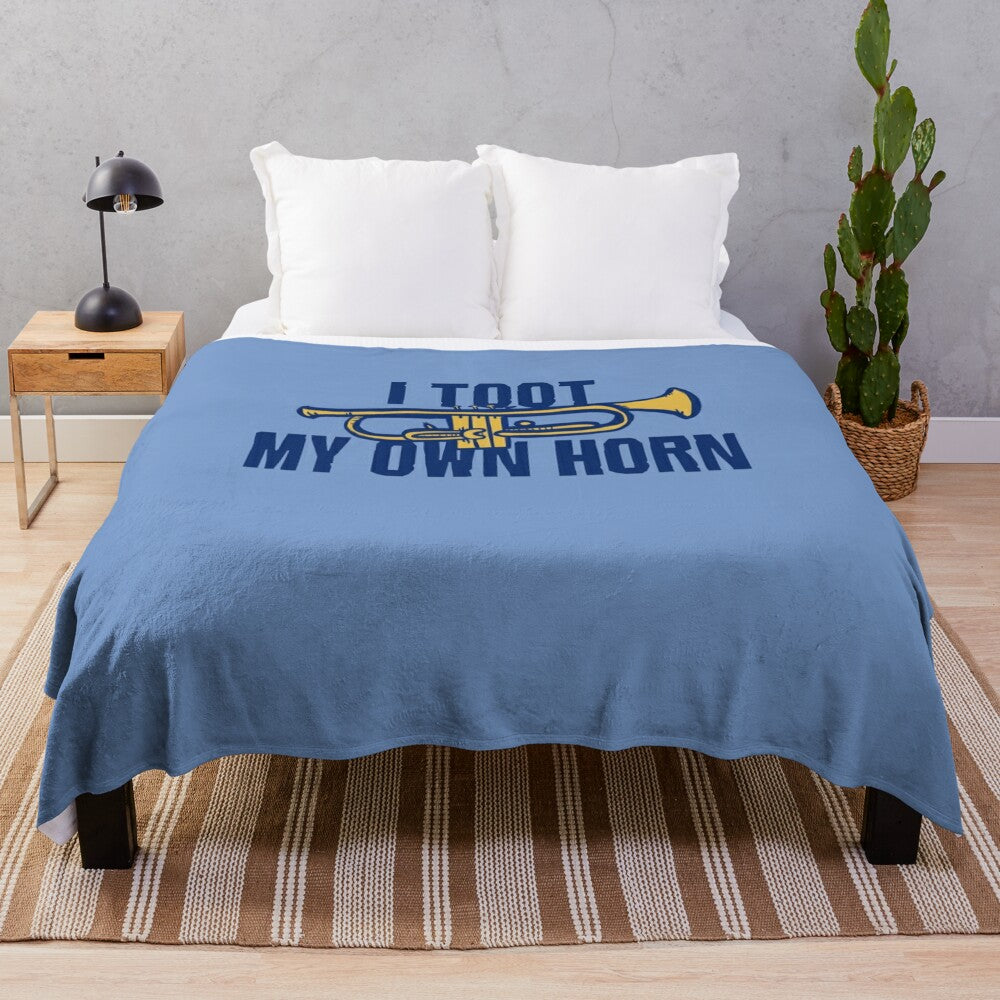 Soft plush blanket featuring the text "I toot my own horn" with a trumpet design