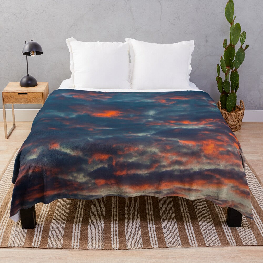 Soft and plush blanket with a cloud pattern design in shades of blue, pink, and orange