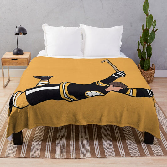 Vintage-inspired plush blanket featuring an iconic photo of Bobby Orr of the Boston Bruins celebrating a goal