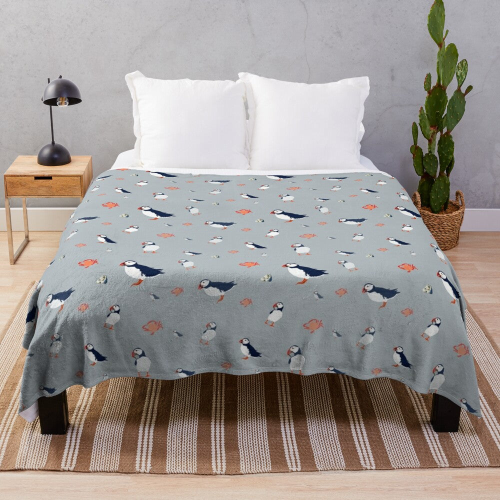 Grey plush blanket with a whimsical puffin bird pattern